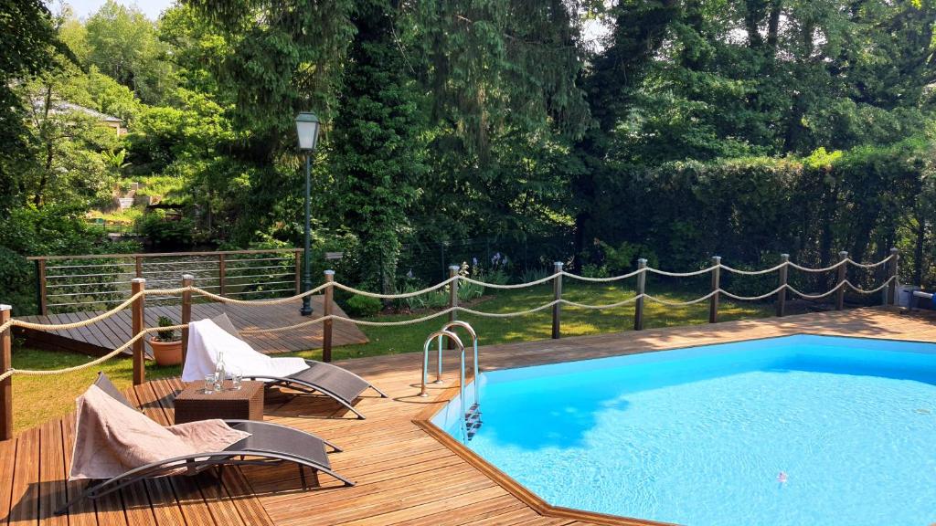 埃皮纳勒LA VALENTINE的一个带椅子和吊床的木制甲板上的游泳池
