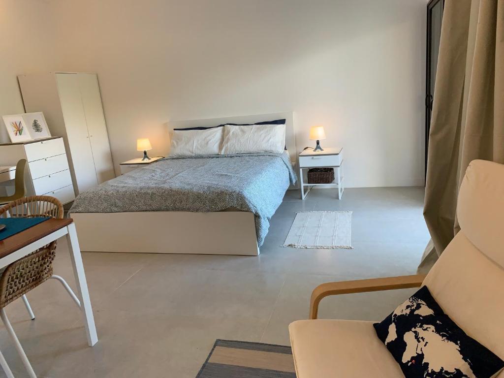 马埃岛Naturalis - Oceanview Residences的卧室配有1张床、1张桌子和1把椅子