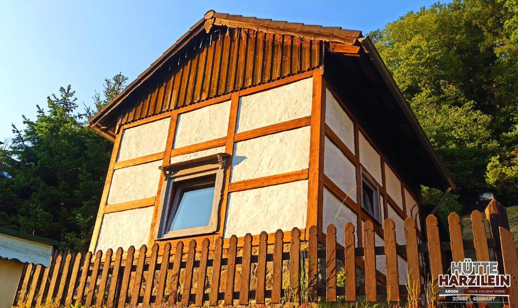ZorgeArode Hütte Harzilein - Romantic tiny house on the edge of the forest的木栅栏后面的小房子