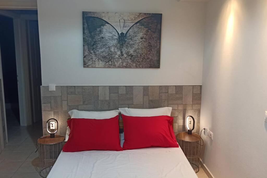 卡诺尼Bed and Garden的一间卧室配有一张带两个红色枕头的床