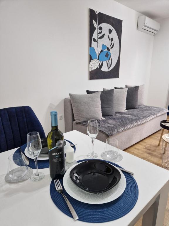 斯雷姆斯卡米特罗维察Apartman Astra的一张桌子,上面放有盘子和酒杯