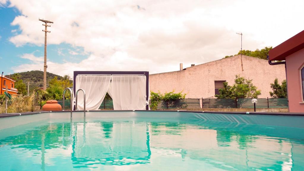 费尔蒂利亚PM Villa Arenosu Guest House的游泳池,中间设有帐篷