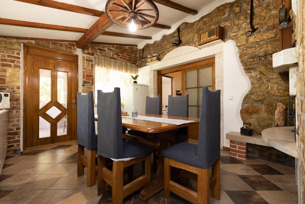 罗维尼Holiday house Hana的一间带木桌和蓝色椅子的用餐室