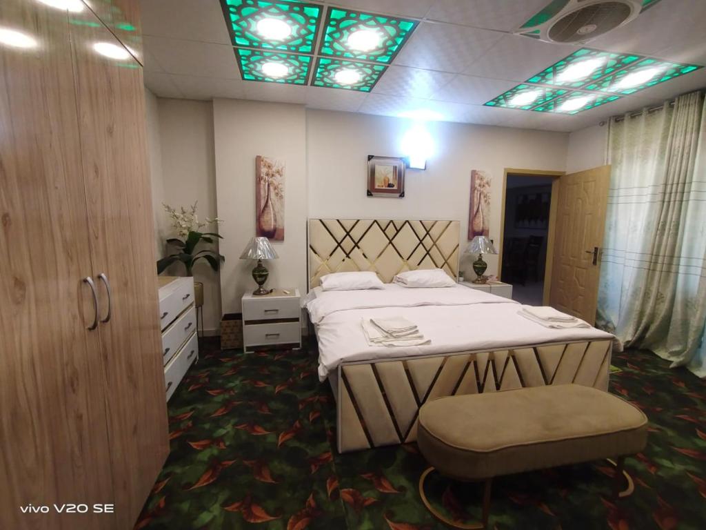 伊斯兰堡Luxury Two-Bedroom apartment的一间卧室设有床铺和彩色玻璃天花板