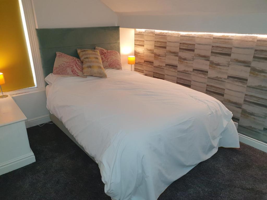 哈德斯菲尔德Lyndene House的卧室配有一张带两个枕头的大白色床