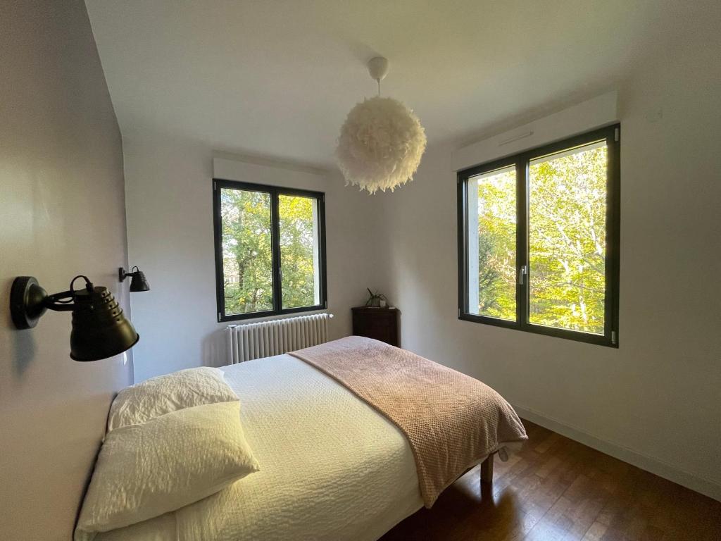 塞莱特Les jardins de l'Hermitage的一间卧室设有一张床和两个窗户。