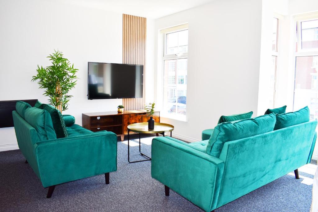 利物浦City Center Apartments FREE PARKING的客厅配有2张蓝色沙发和电视