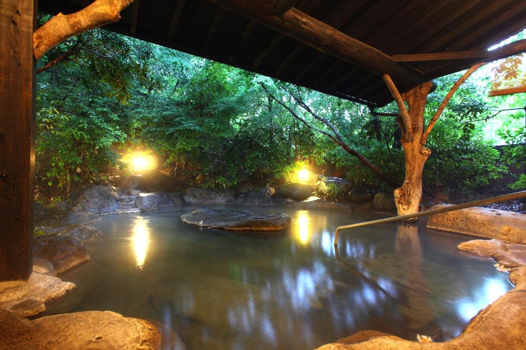 南小国町山忍酒店的树木和灯光的海水游泳池