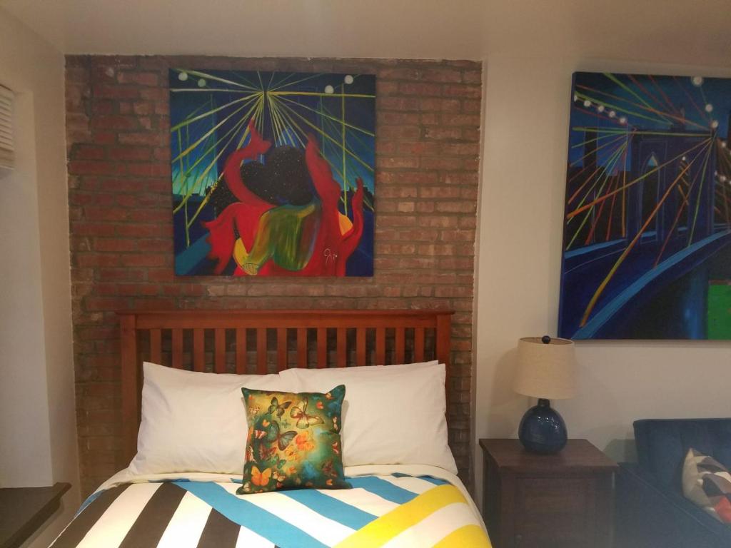纽约The Harlem Getaway的卧室配有一张壁画和两张画的床铺。