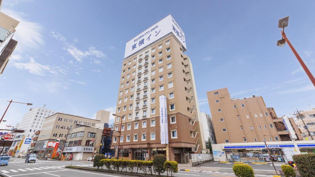 宫崎Toyoko Inn Miyazaki Chuo-dori的一座高大的建筑,上面有钟