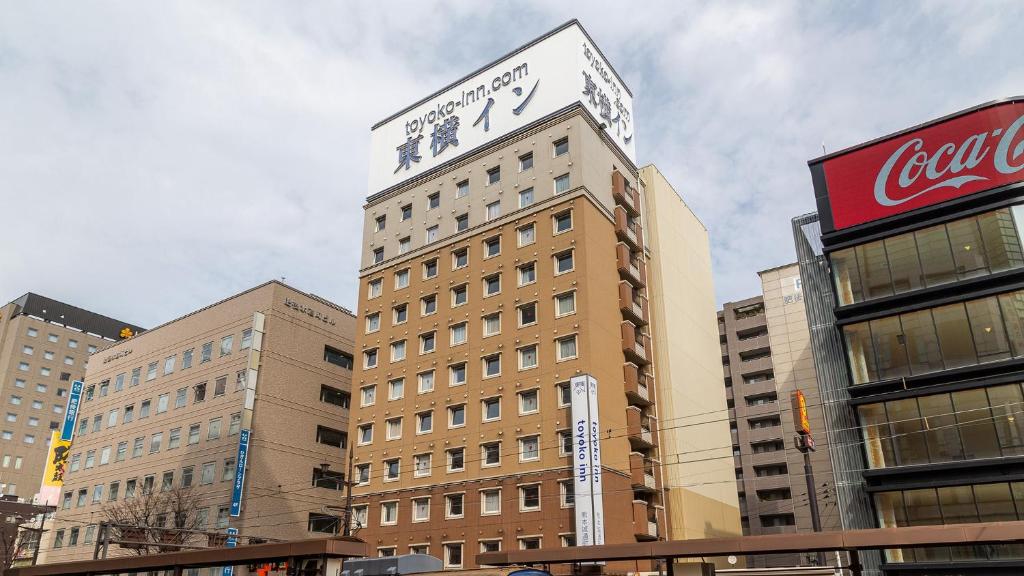 熊本Toyoko Inn Kumamoto-jyo Toricho Suji的一座高大的建筑,上面有钟