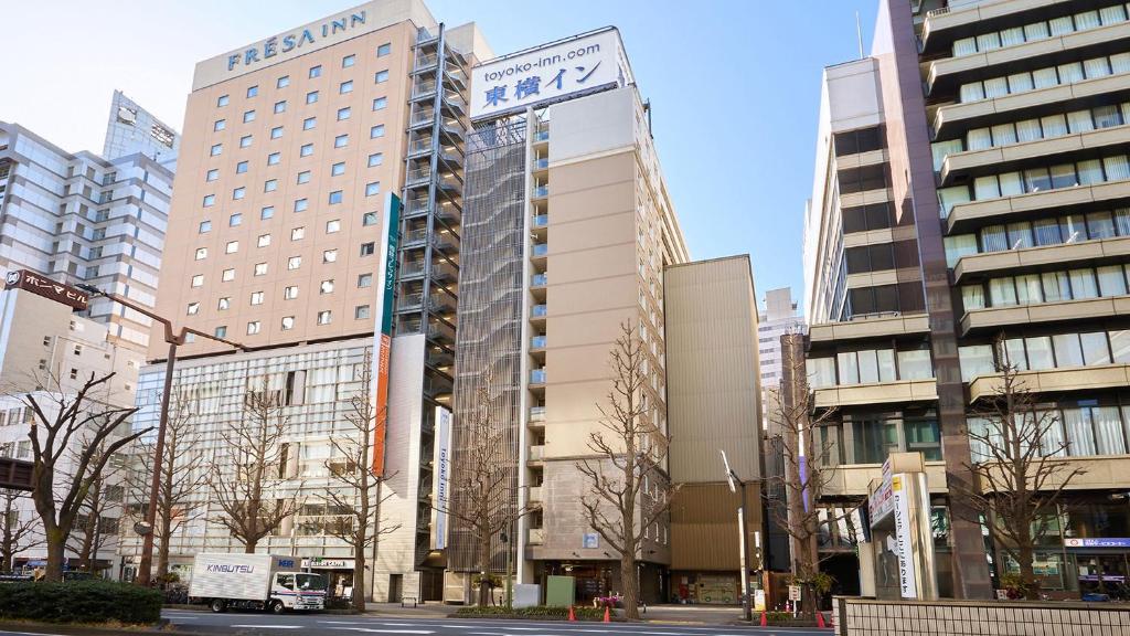 川崎Toyoko Inn Kawasaki Ekimae Shiyakusho-dori的城市中一群高大的建筑