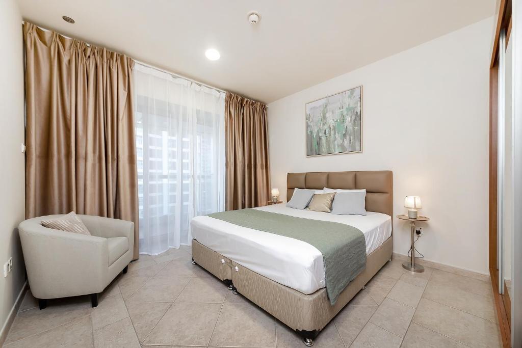 迪拜Luxury Princess Tower 1 Br Brand New Furnished apartment的卧室配有床、椅子和窗户。