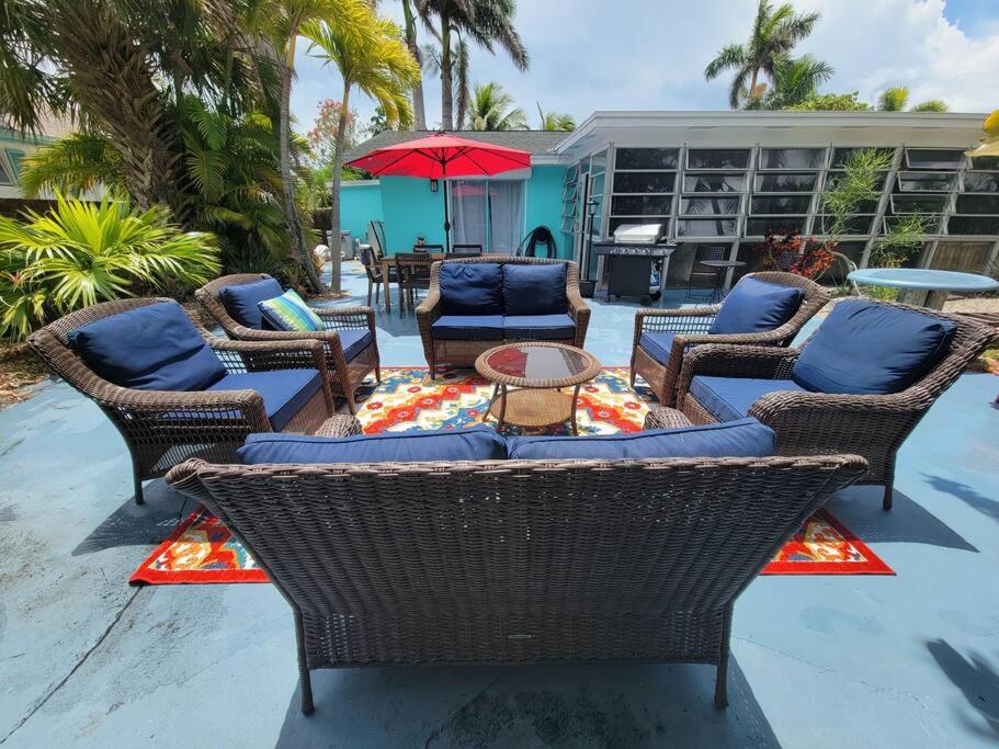 皮尔斯堡Beach & Surf Hacienda on Hutchinson Island的庭院设有藤椅和带遮阳伞的桌子。