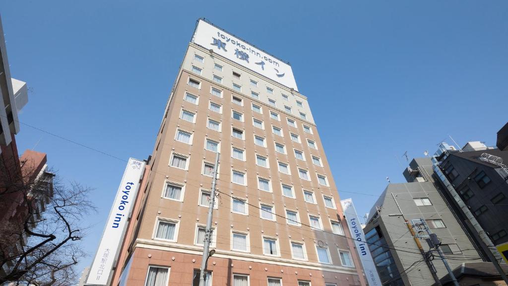 东京Toyoko Inn Tokyo Yamanote sen Otsuka eki Kita guchi No 2的一座高大的棕褐色建筑,上面有标志