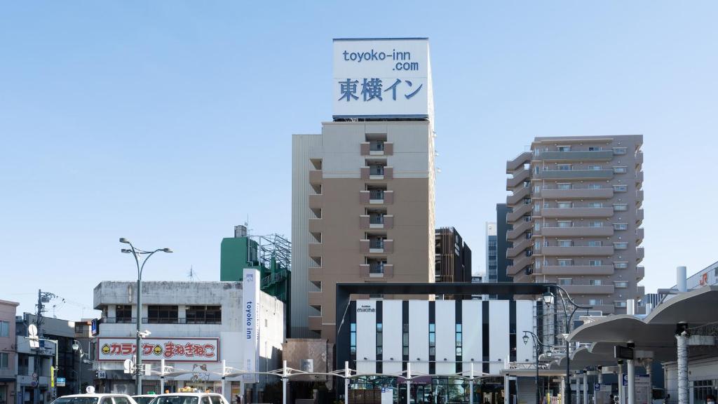 藤枝Toyoko Inn Shizuoka Fujieda eki Kita guchi的一座高大的建筑,上面有城市的标志