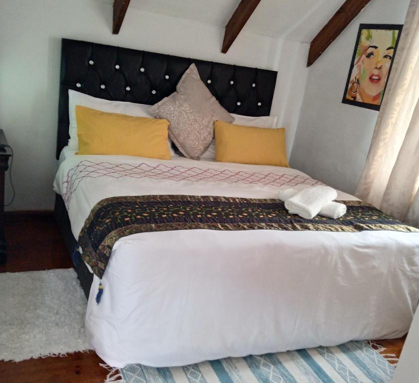开普敦Room in BB - Zagorskis Bed and breakfast close to the beach and commodities的卧室配有一张带黄色枕头的大型白色床。