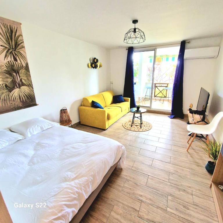 圣吉尔莱班Studio P'ti Boucan的一间卧室配有一张床和一张黄色的沙发