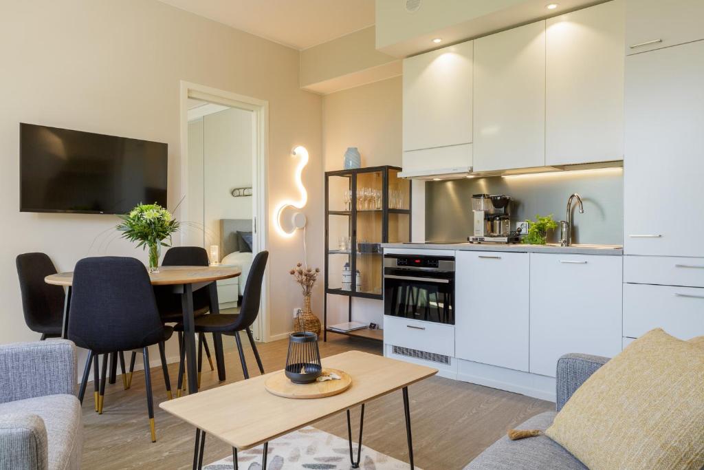 卡拉约基Apartment Marinan Portti B37 kaksio Kalajoki的厨房以及带桌椅的起居室。