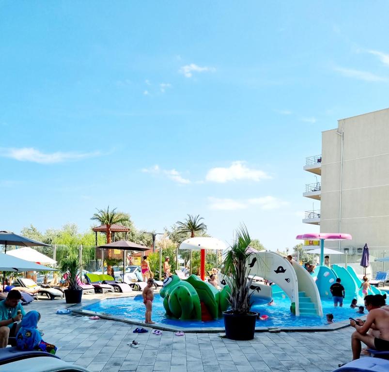 北马马亚-讷沃达里Beach Resort Studio Fitness-spa-pool的度假村的游泳池,人们在里面玩耍