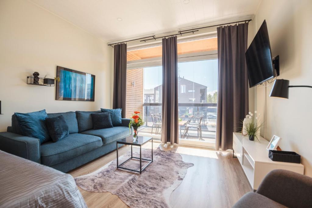 卡拉约基Apartment Aurinkoranta D8 saunallinen yksiö Kalajoki的客厅设有蓝色的沙发和大窗户