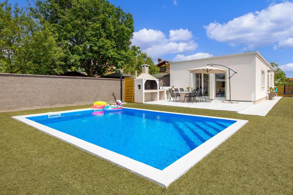 罗波里卡Cosy holiday home Infinity with pool and BBQ的一座房子的院子内的游泳池