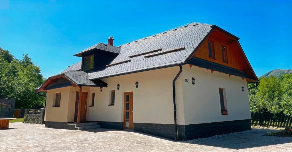 切拉德纳Ubytování v soukromí s bazénem Tři Splavy的一座白色的小建筑,有黑色的屋顶