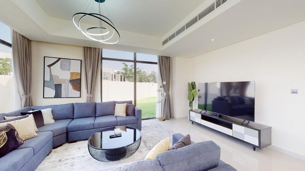 迪拜Primestay - Odora 6BR, Akoya Oxygen的客厅配有蓝色的沙发和电视
