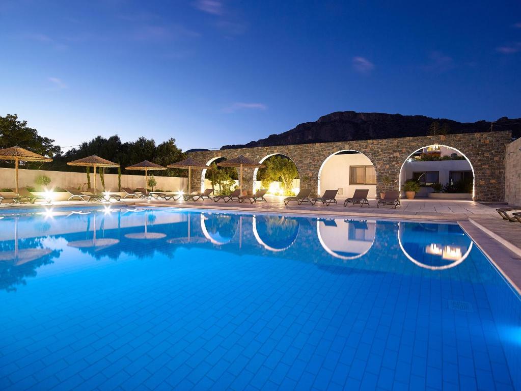 考特索纳里Coriva Beach Hotel & Bungalows的夜间在度假村的一个大型游泳池