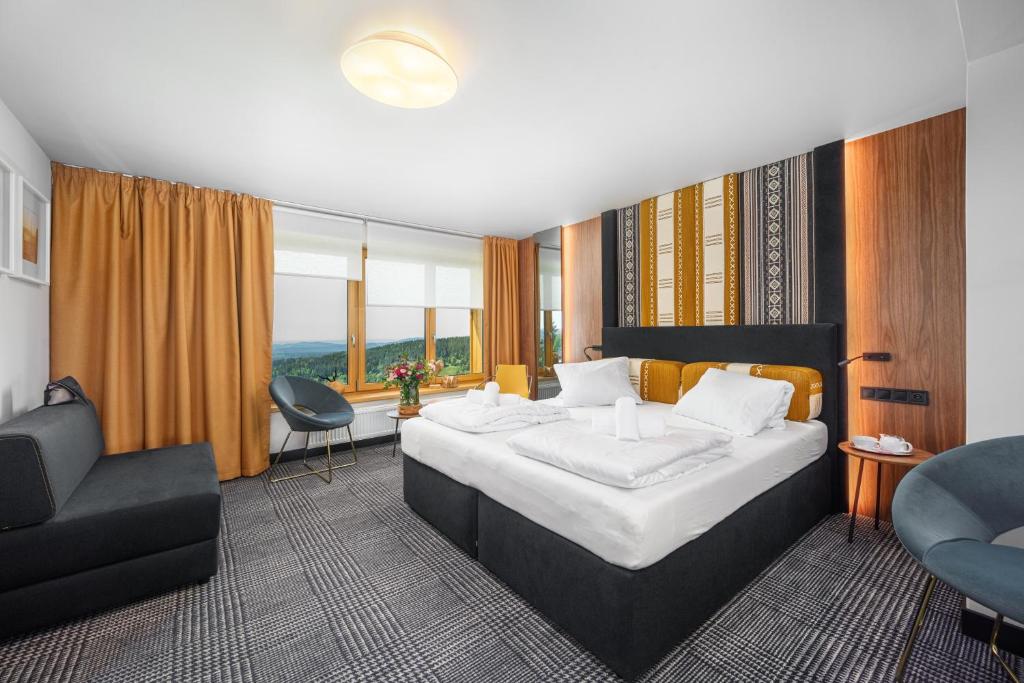 贝德日霍夫Hotel Premier- Adults Only的配有一张床和一把椅子的酒店客房