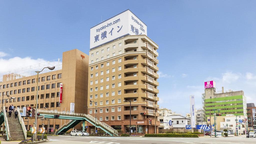 德岛Toyoko Inn Tokushima Ekimae的一座高大的建筑,上面有标志