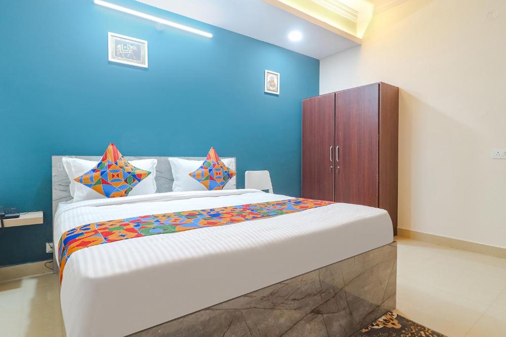 海得拉巴FabHotel Broholic Suites I的一间卧室设有一张大床和蓝色的墙壁