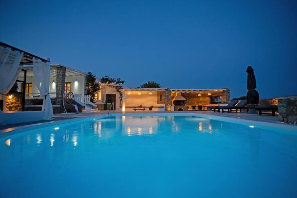 米克诺斯城Villabellum Mykonos的夜间大型蓝色游泳池
