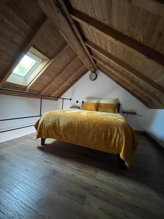 瓦兹河畔欧韦La Maison du Pere Pilon avec petit dejeuner的阁楼卧室配有黄色的床