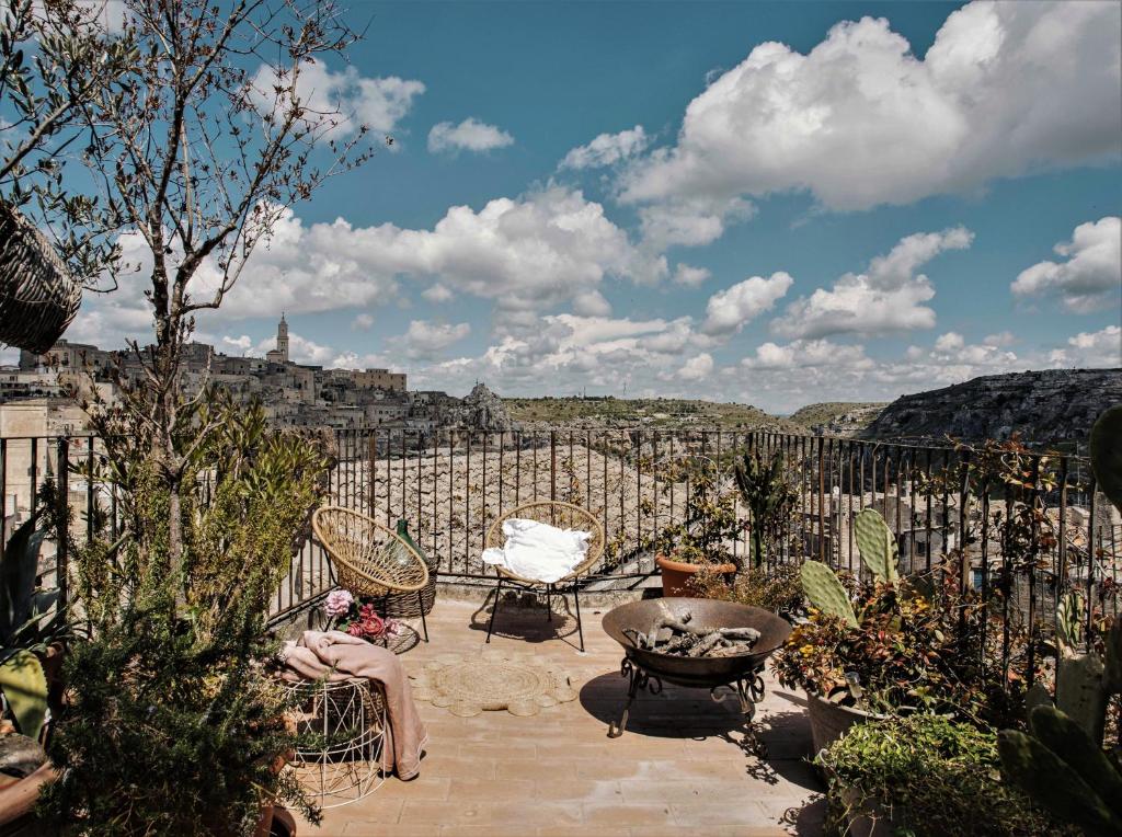 马泰拉科尔特圣莱昂纳多旅馆的坐在享有城市美景的庭院中的女人