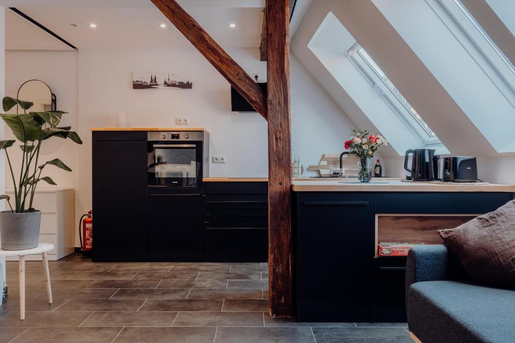 不莱梅Luxuriöse und stilvolle Ferienwohnung in bester Lage Bremens的阁楼厨房配有黑色橱柜和水槽
