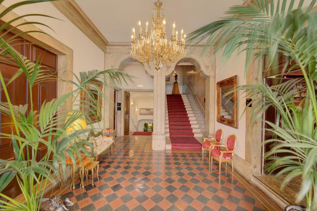 里斯本Palácio das Especiarias的走廊上设有吊灯和植物楼梯