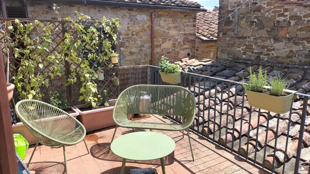 波吉奥的圣多纳托La tua casa nel Chianti的植物庭院里的两把椅子和一张桌子