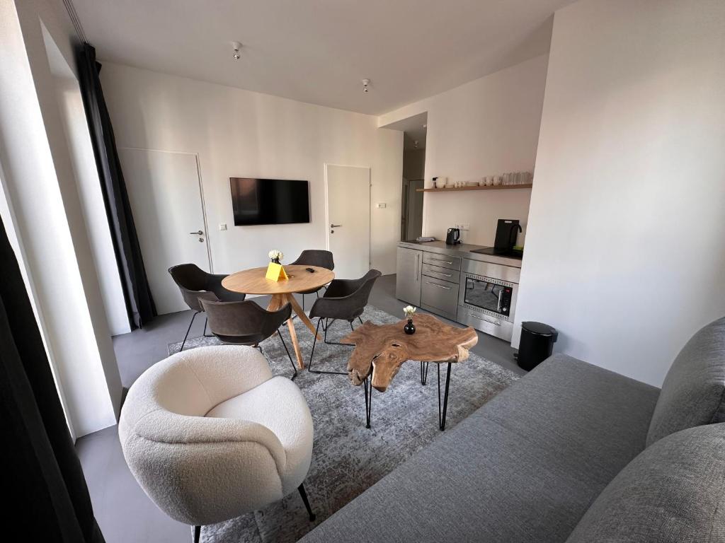 林茨Rilke Apartments的客厅配有沙发和桌椅