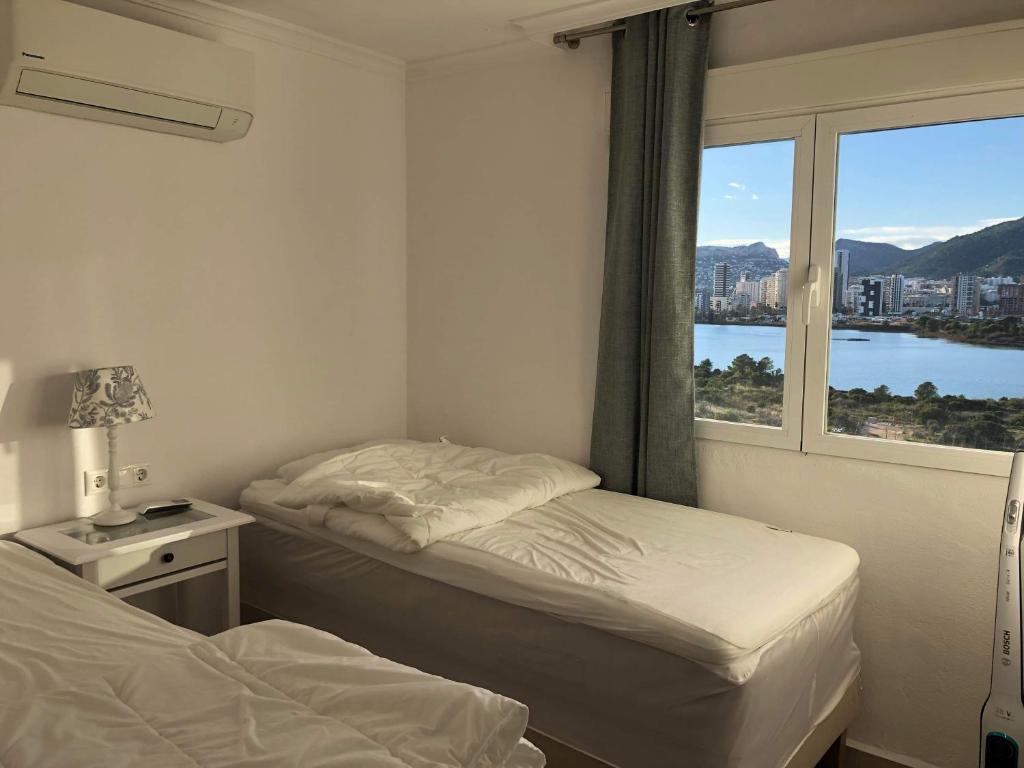 卡尔佩Duplex Penthouse的一间卧室设有两张床和一个美景窗户。