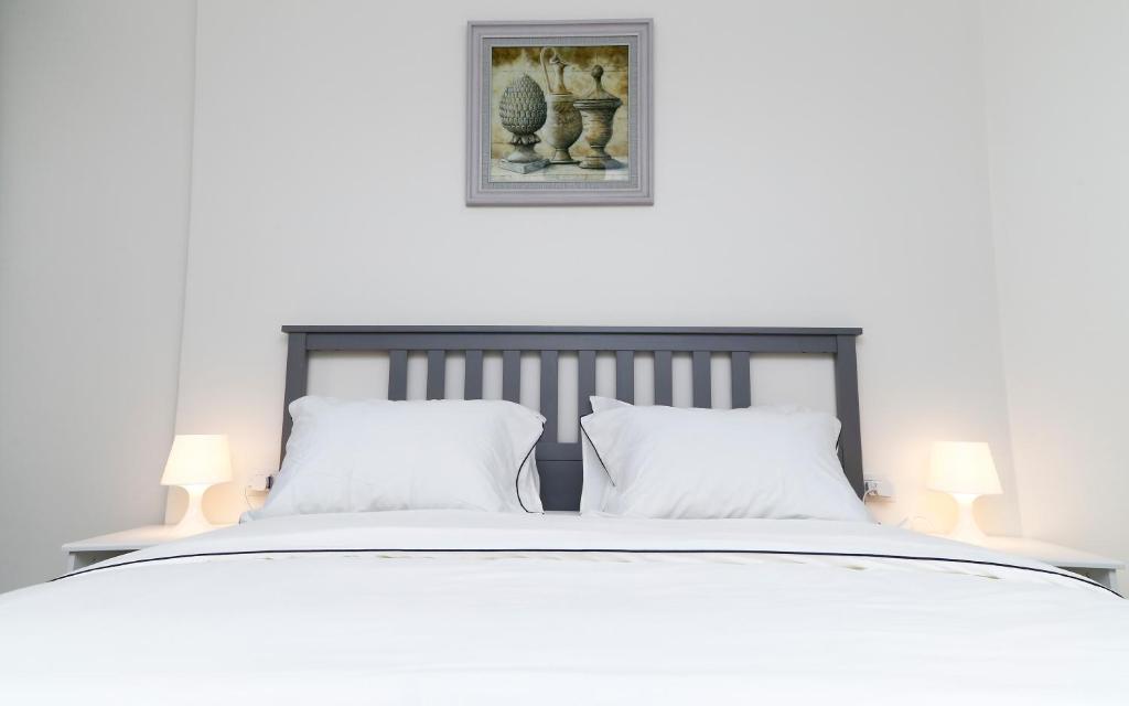 塞得港Porto Said Tourist Resort Luxury Hotel Apartment的一张带两个白色枕头和两盏灯的白色床