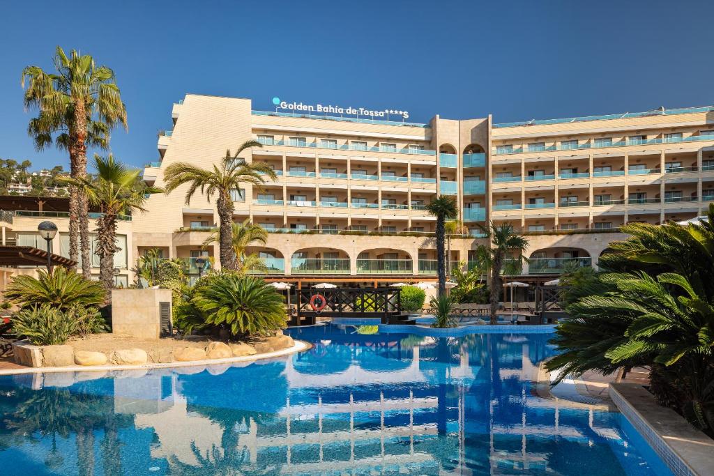滨海托萨Golden Bahía de Tossa & Spa 4* Sup.的大楼前设有游泳池的酒店