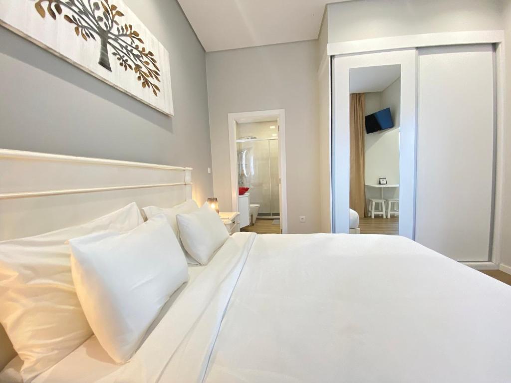 塞图巴尔Canto Doce的卧室内的白色床和白色枕头