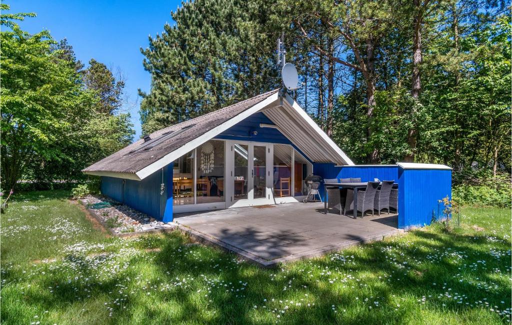 NordbyBeautiful Home In Sams With Kitchen的一座小蓝色房子,在田野里设有桌子