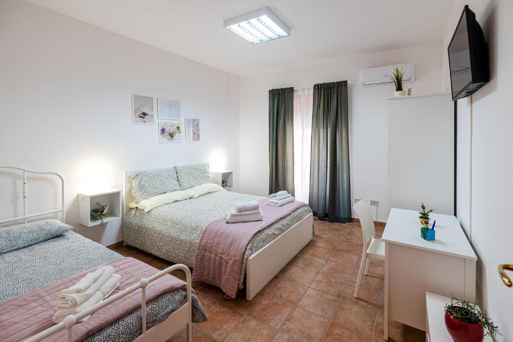 莫塔卡玛斯特拉Casa Del Corso的一间卧室配有两张床、一张桌子和一台电视。
