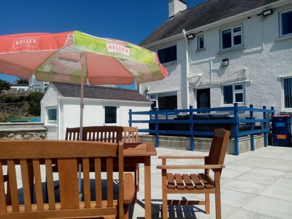 阿姆奇Anglesey home by the sea的庭院内桌椅和遮阳伞