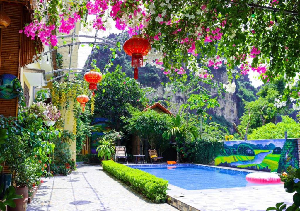 宁平Tam Coc Viet Ha Homestay的花园内的游泳池,有红色灯笼