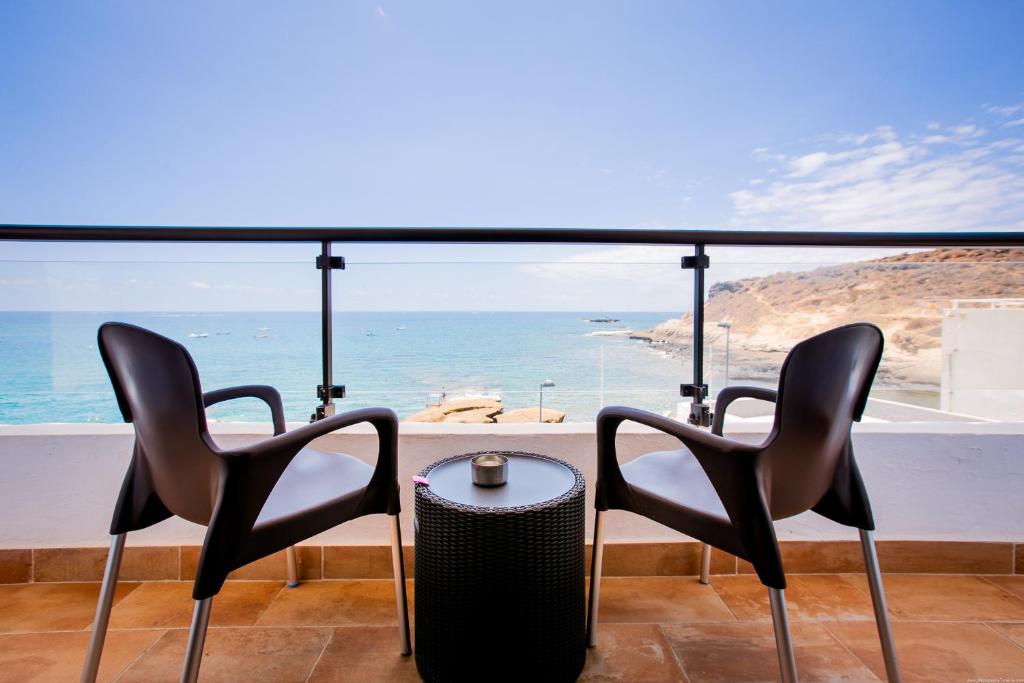 阿德耶Apartments La Caleta Sunrises的两张椅子和一张桌子,享有海景