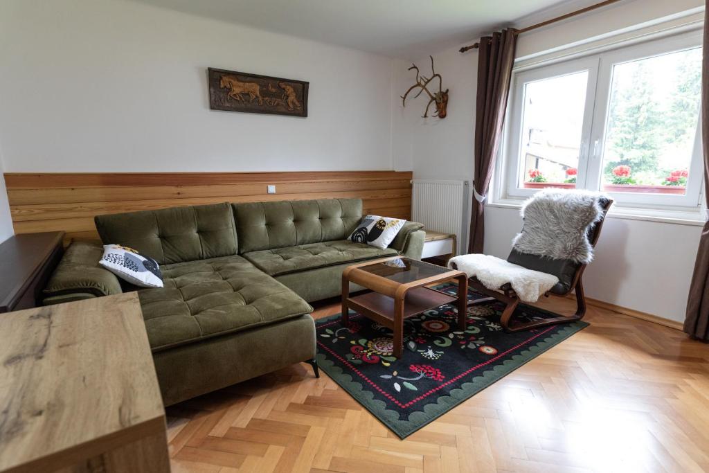 戈德马图杰克Sobe v Gozdu的客厅配有绿色沙发和椅子