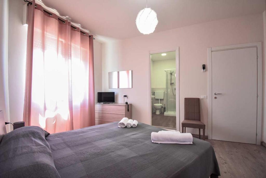 卡拉拉hotel La pineta的一间卧室配有一张大床和两条毛巾